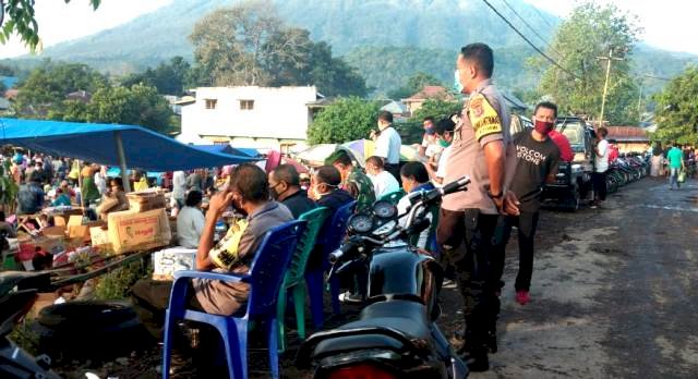 Bhabinkamtibmas Brigpol Fransiskus Yohanes monitoring sekaligus pembagian masker di pasar Mirek Kec. Witihama