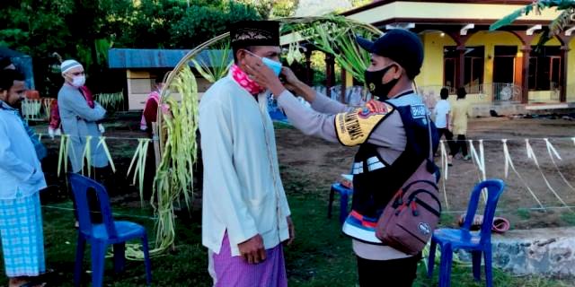 Terapkan Prokes, Bhabinkamtibmas Bagi Masker Saat Pengamanan Ibadah Sholat Idul Fitri 1 Syawal 1442 H