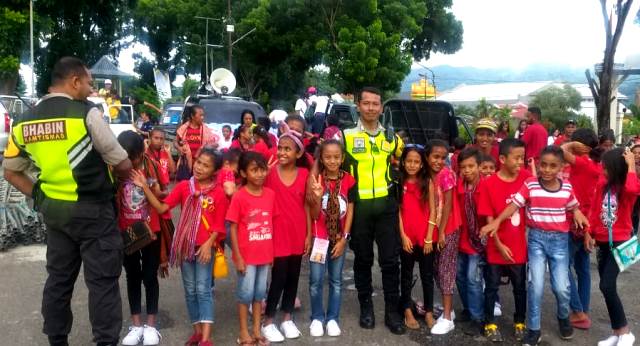Berikan Rasa Aman dan Nyaman, Bhabinkamtibmas Bripka Thomas Raya Kawal Pawai Kontingen Pesparani